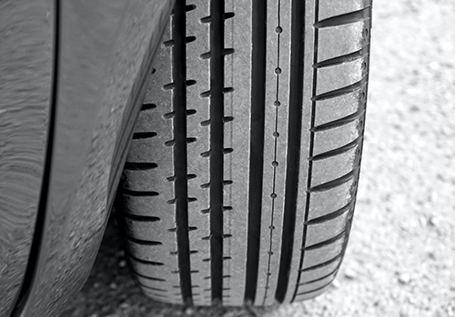 A car tire with safe tread depth is photographed.