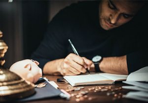 Man writing notes about his relationship with finances