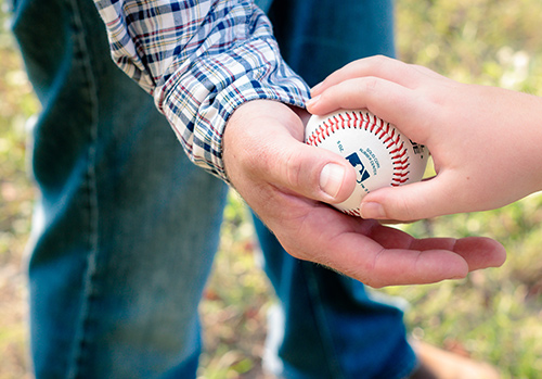 A sports parent holds a baseball.