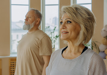 An elderly couple is photographed in an exercise room.