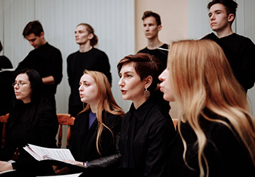 Choir members are photographed singing.