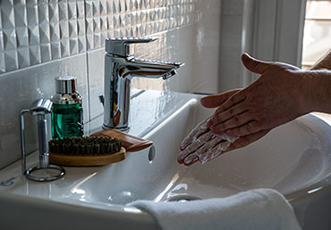 A man uses hand soap to wash his hands.
