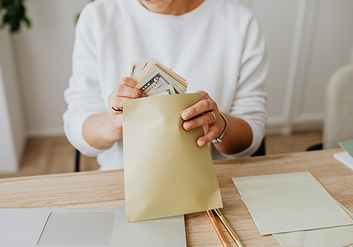 Woman practices cash stuffing to save money.