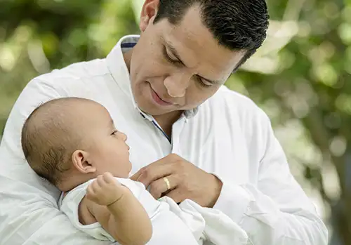 father holding baby thinkig about term life insurance