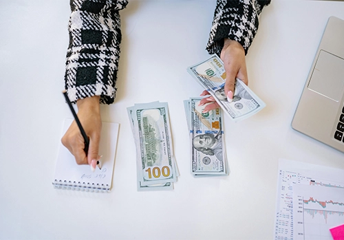 a person taking notes while counting money