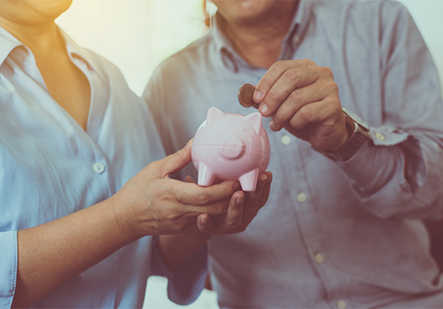 life insurance annuity couple putting coin in piggy bank large image