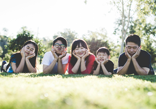 A happy young family outdoors, representing the long-term security and legacy protection offered by indexed universal life (IUL) insurance.