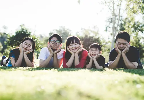 A happy young family outdoors, representing the long-term security and legacy protection offered by indexed universal life (IUL) insurance.