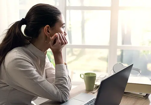 Pensive young woman at home looking away 