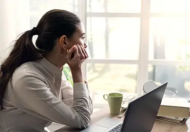 Pensive young woman at home looking away